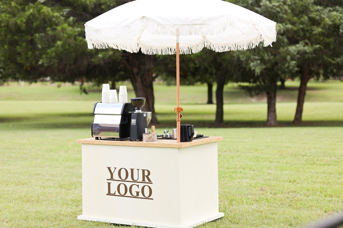 Coffee cart with a fringe umbrella mocked up with placeholder logo branding