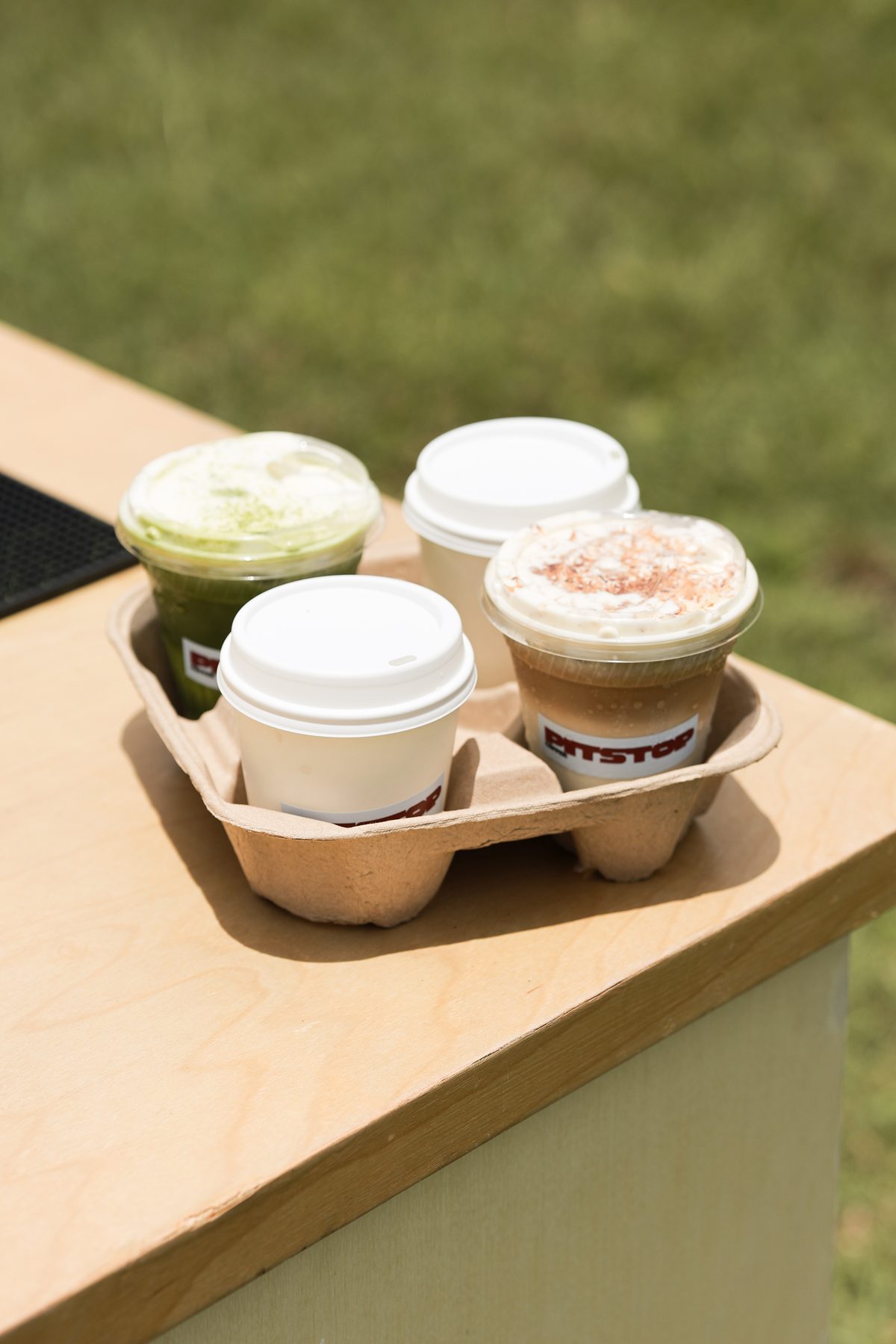 A tray of four Pit Stop branded coffees
