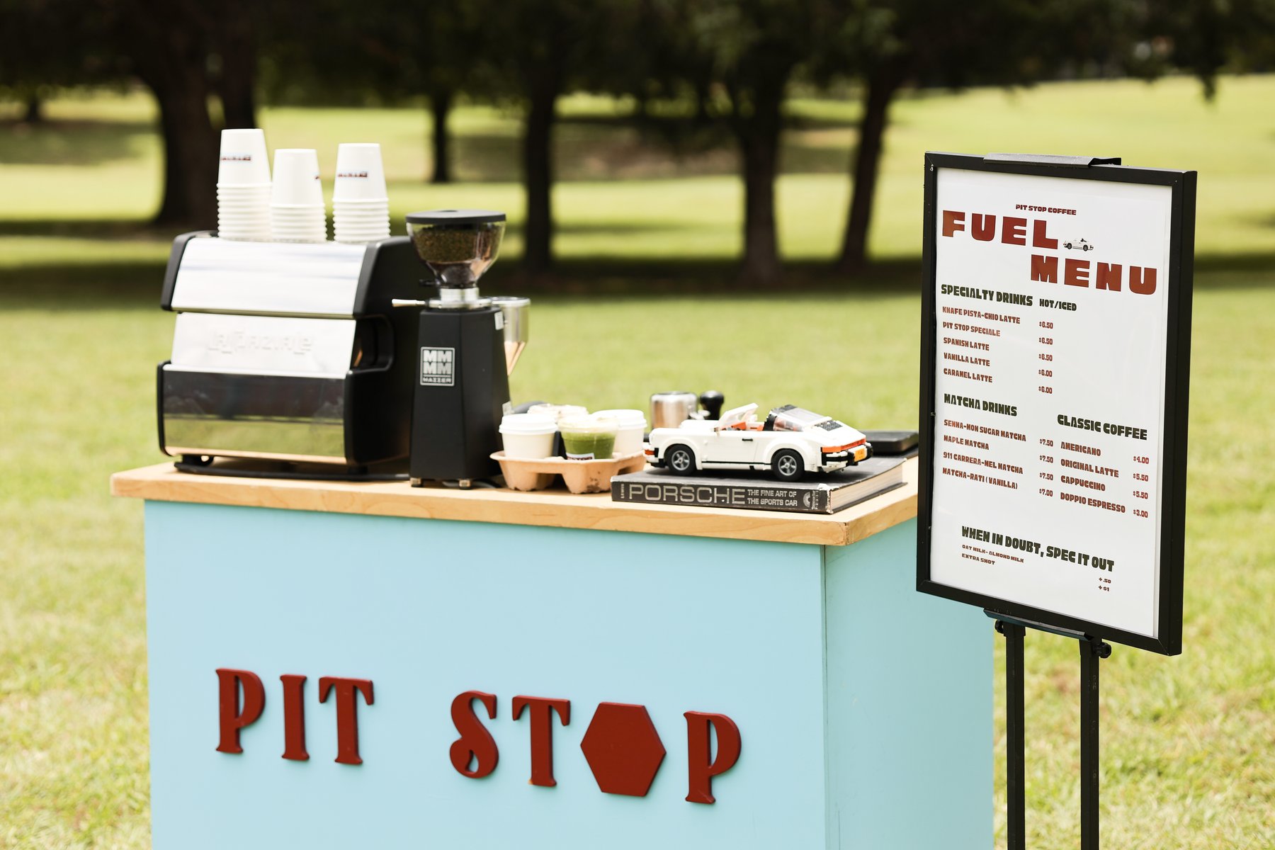 Pit Stop Coffee's branded cart and Fuel Menu sign set up outdoors